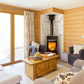 Enjoy picturesque views from Chalet Les Sauges lovely living room & cosy log burner.
